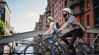 A couple rides their bikes through Hamburg