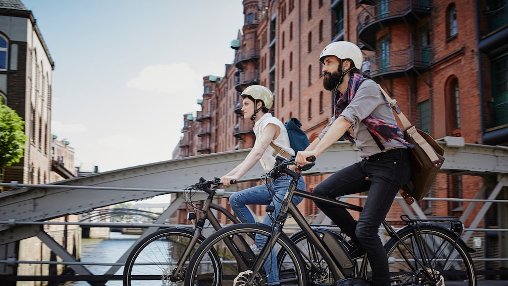 A couple rides their bikes through Hamburg