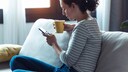 A young woman with a smartphone on the couch