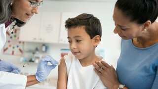 COVID-19 Vaccination for Children Aged Five and Up: Young Boy and Woman at a Doctor's Office