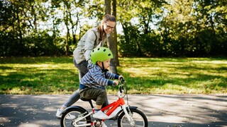 buying a children's bike: Mother pushes her child on the bike