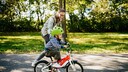 buying a children's bike: Mother pushes her child on the bike