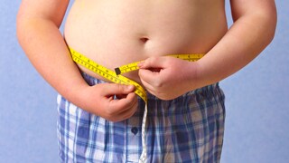 Overweight Children: Boy Measures His Waistline