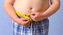 Overweight Children: Boy Measures His Waistline