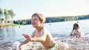 Dangers of Swimming: Children Play in the Water at a Lake's Shore