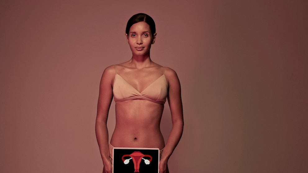 Woman holding a picture of the female sexual organ.
