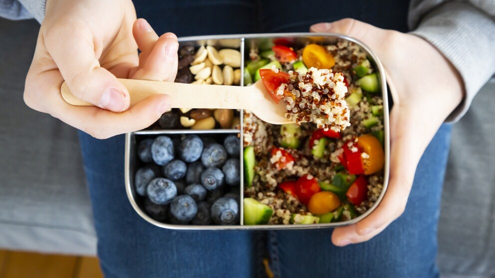 Healthy snacks in a tin with berries, quinoa etc.