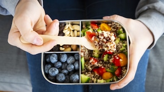 Healthy snacks in a tin with berries, quinoa etc.