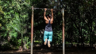 Dead Hang: A woman hangs from a pull-up bar