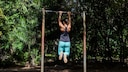 Dead Hang: A woman hangs from a pull-up bar