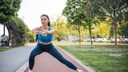 A woman performs side lunges.