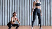 A woman performs jump squats.