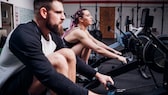 How long should men and women be able to row for basic fitness?