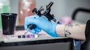 Getting Eyes Tattooed: Hand Holds Tattoo Needle