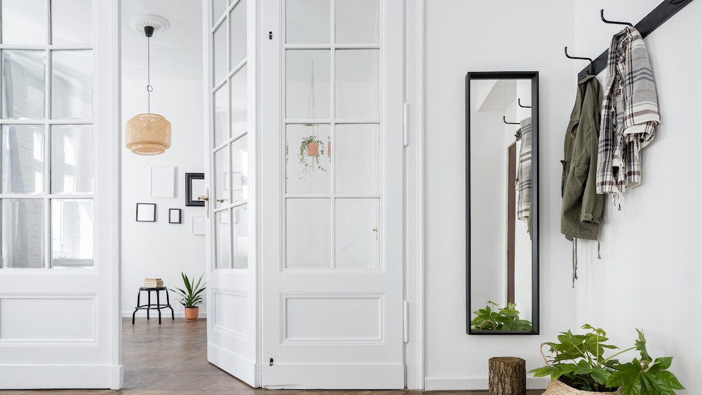 A bright hallway with a coat rack and narrow mirror