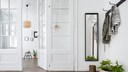 A bright hallway with a coat rack and narrow mirror