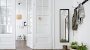 A bright hallway with a coat rack and narrow mirror