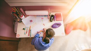 A child is drawing at a child-friendly table