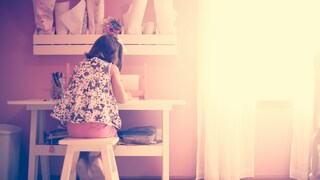 Child Sitting at a White Desk