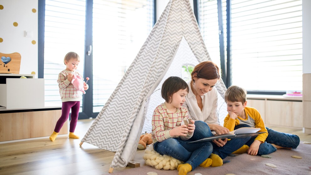 Mother Reading a Book with Her Children in a Cozy Teepee