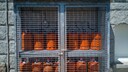 Gas Cylinders: Many red gas cylinders secured behind a grate