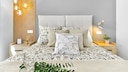 Various bedside lamps next to a bed