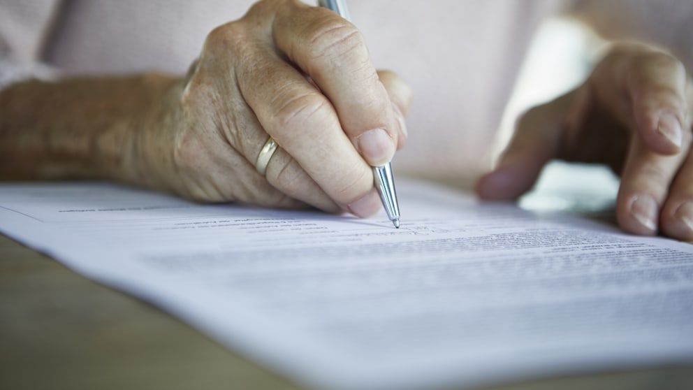 Woman probably signs a certificate of eligibility for housing