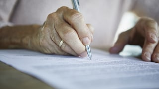 Woman probably signs a certificate of eligibility for housing