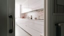 The back kitchen conceals chaos and kitchen appliances, keeping the open-plan kitchen tidy.