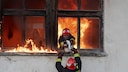 Firefighters rescue a cat from a burning house
