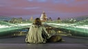 A homeless man and his dog at night on the Millennium Bridge with St. Paul's Cathedral in the background.