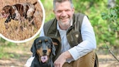 Hunter and biologist Torsten Reinwald poses with his hound in the forest.