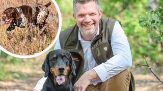 Hunter and biologist Torsten Reinwald poses with his hound in the forest.