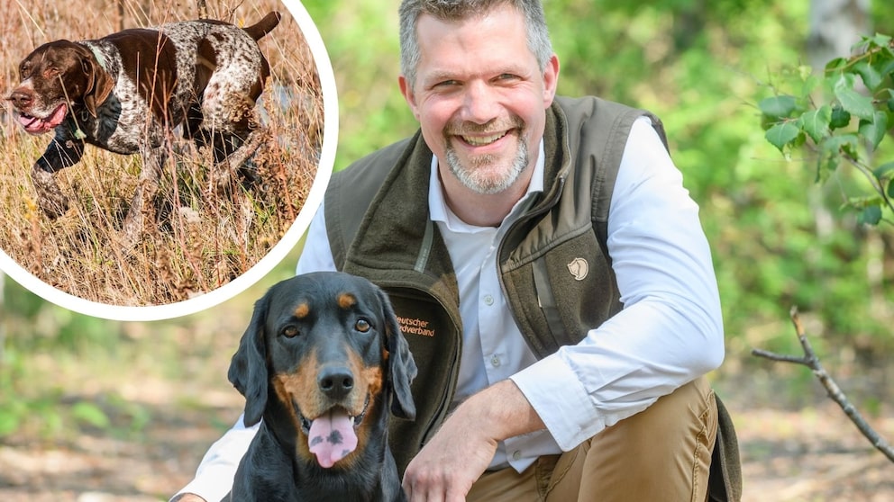 Hunter and biologist Torsten Reinwald poses with his hound in the forest.