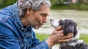 An elderly man talks to his dog