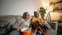 Same-Sex Couple Watches TV with Dog on the Couch