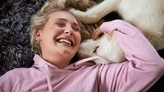 A woman cuddles with a dog
