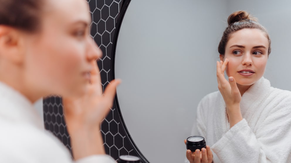 Woman with cream in front of the mirror