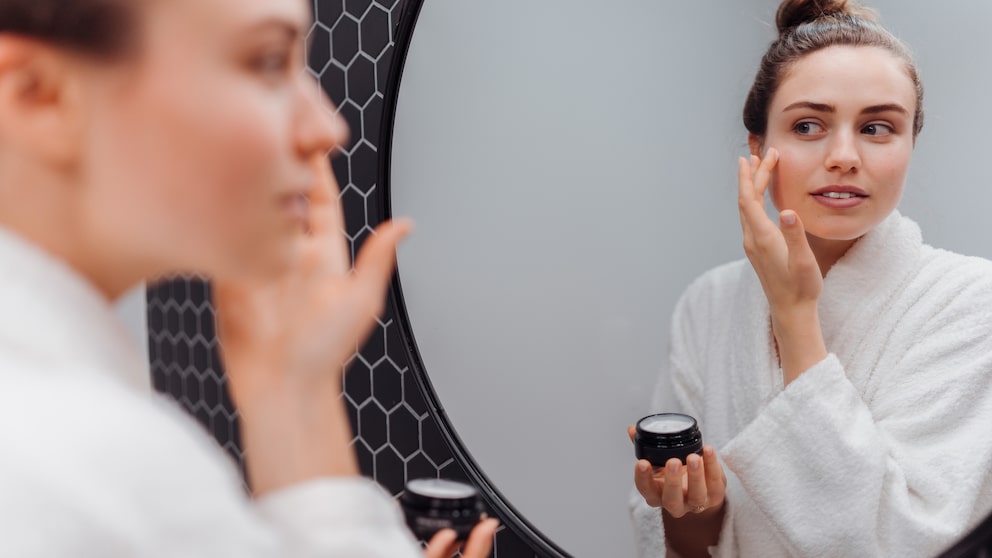 Woman with cream in front of the mirror