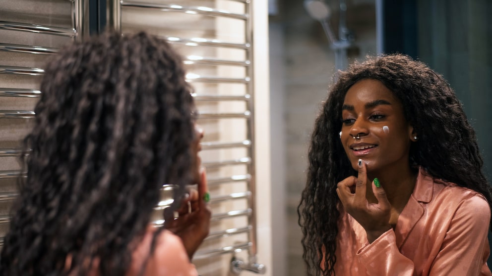 Woman applying night cream in front of a mirror. Could be any other cream, of course, but here the setting is relatively dark, so it can pass for evening. Do you know how difficult it is to find cream photos that aren't overexposed? It's like only applying cream in the morning