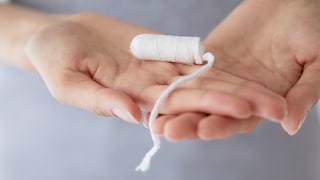 Women's hands holding a tampon that could be a probiotic tampon
