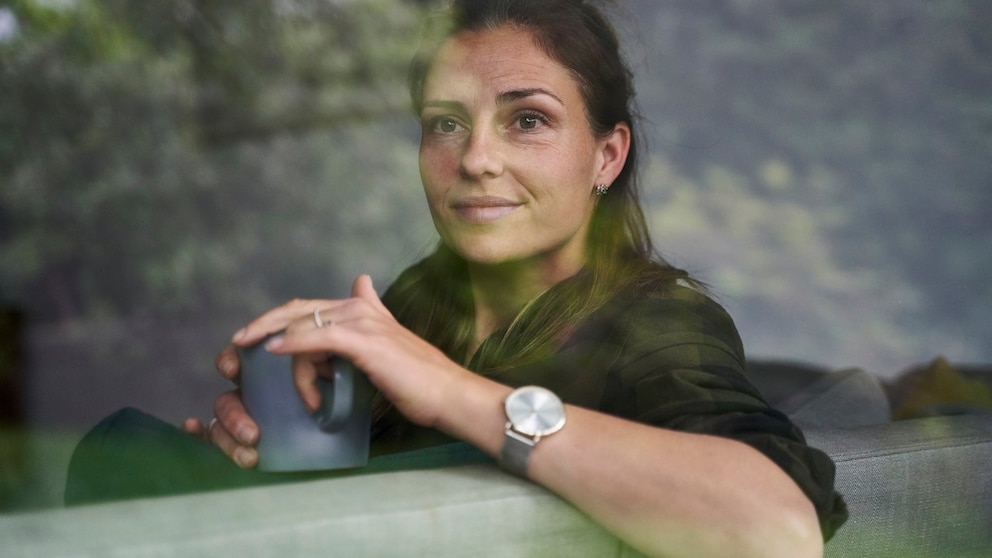 Woman with a cup of tea on the sofa. Definitely helps during the menopause. And like this too. A cup of tea is always good, isn't it?