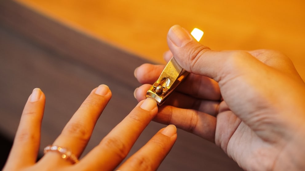 Woman Trims Nails with Nail Clippers