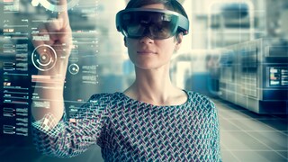 Woman with Microsoft HoloLens behind projected screen