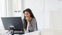 Woman sitting in front of a computer monitor