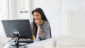 Woman sitting in front of a computer monitor