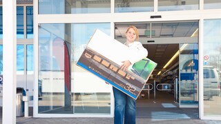Woman Carries TV Out of Electronics Store