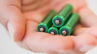 Hand with four AAA batteries