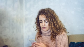 Woman Looks Unhappily at Smartphone