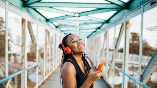 Bluetooth Auracast: Young Woman Listens to Music via Bluetooth Headphones